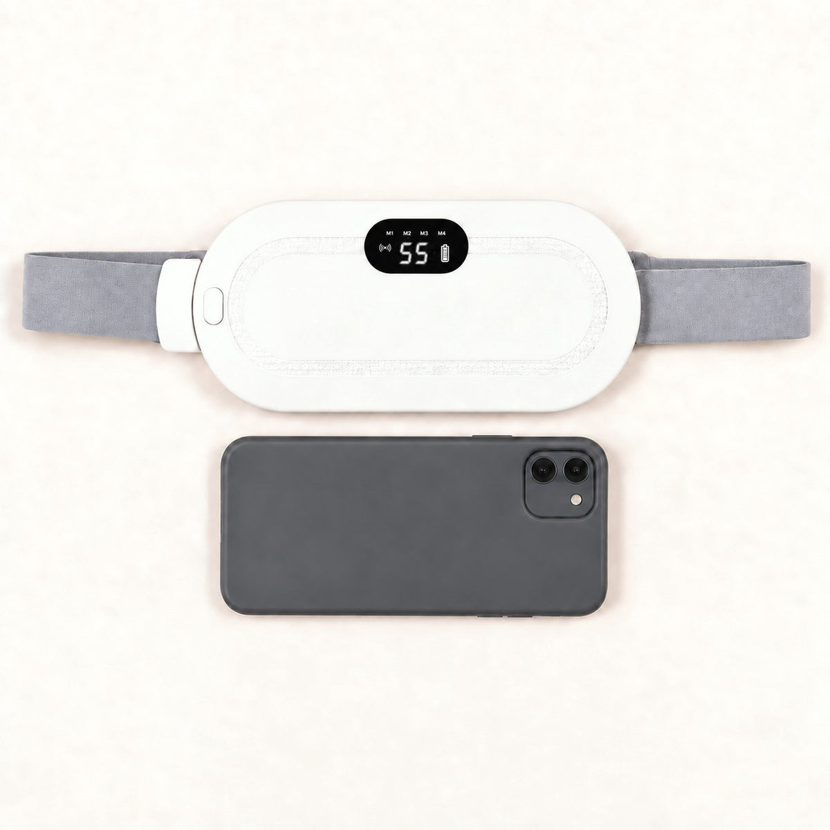 Ceinture chauffante CHALYNE blanche comparée à un smartphone pour montrer sa taille réelle