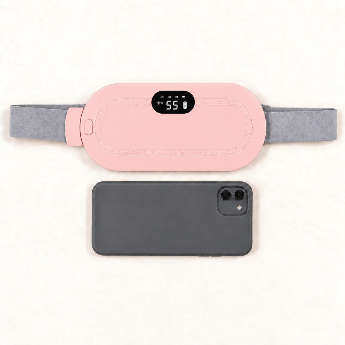 Ceinture chauffante CHALYNE rose comparée à un smartphone pour montrer sa taille réelle
